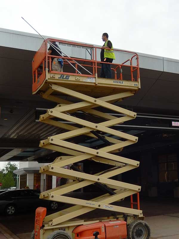 men on lyft repairing storefront