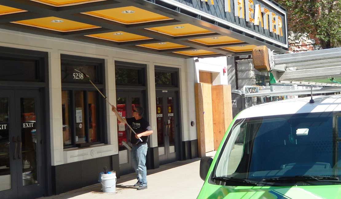 theater-windowcleaning man washing storefront window